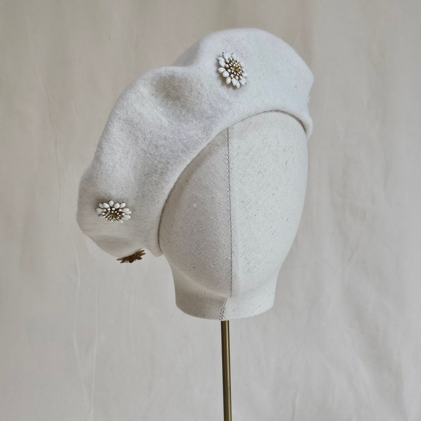 Ivory wool beret with beautiful white daisy embellishments, front view.