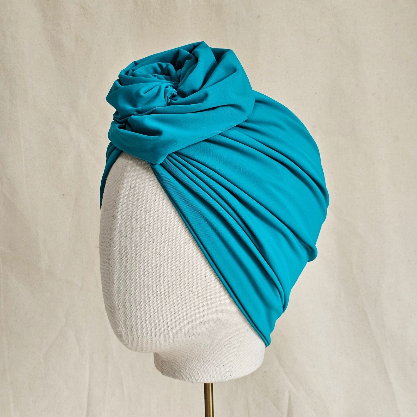 Jade softly gathered swim turban with sculpted rose knot, side view.