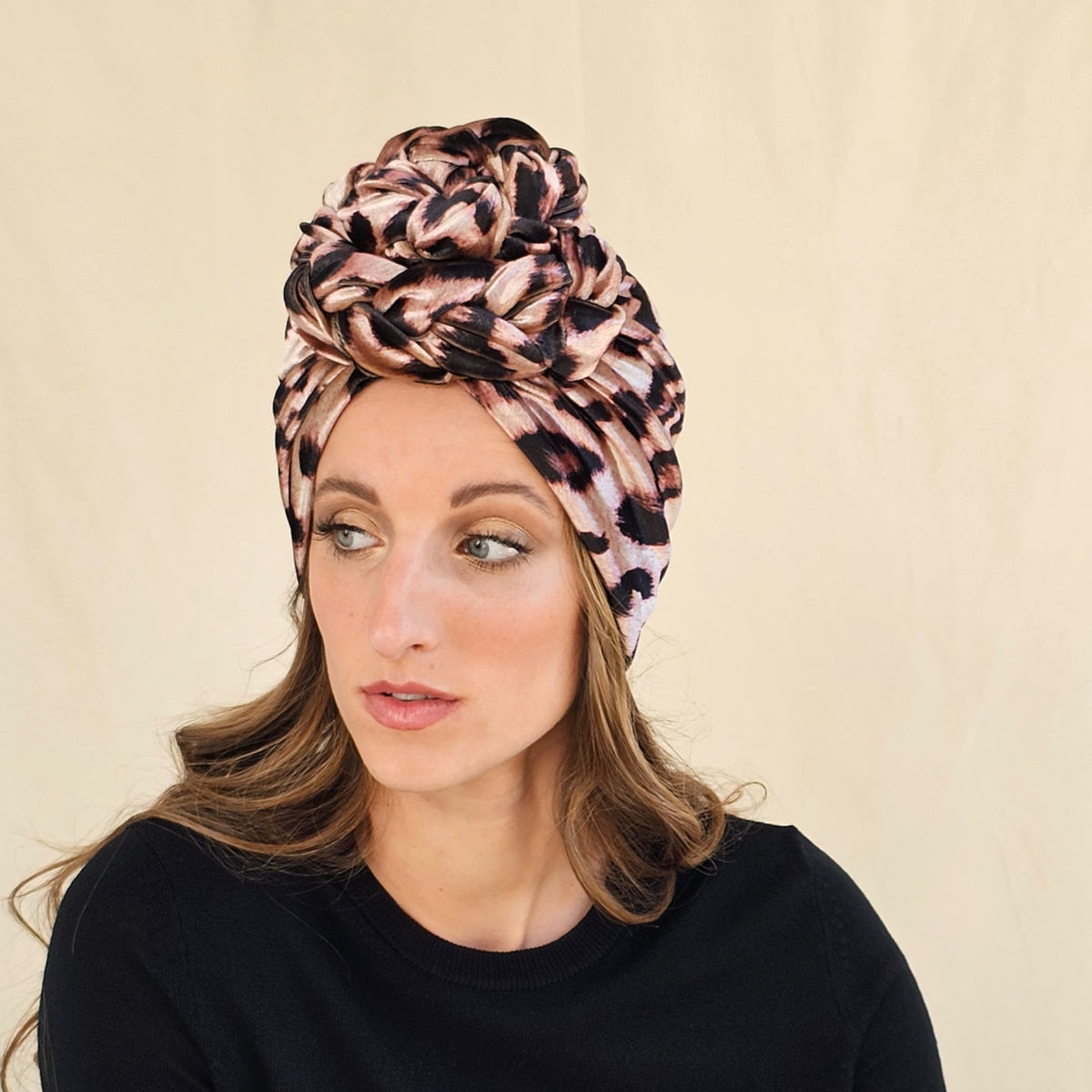 Angled view of leopard print velour turban with a braid rose.