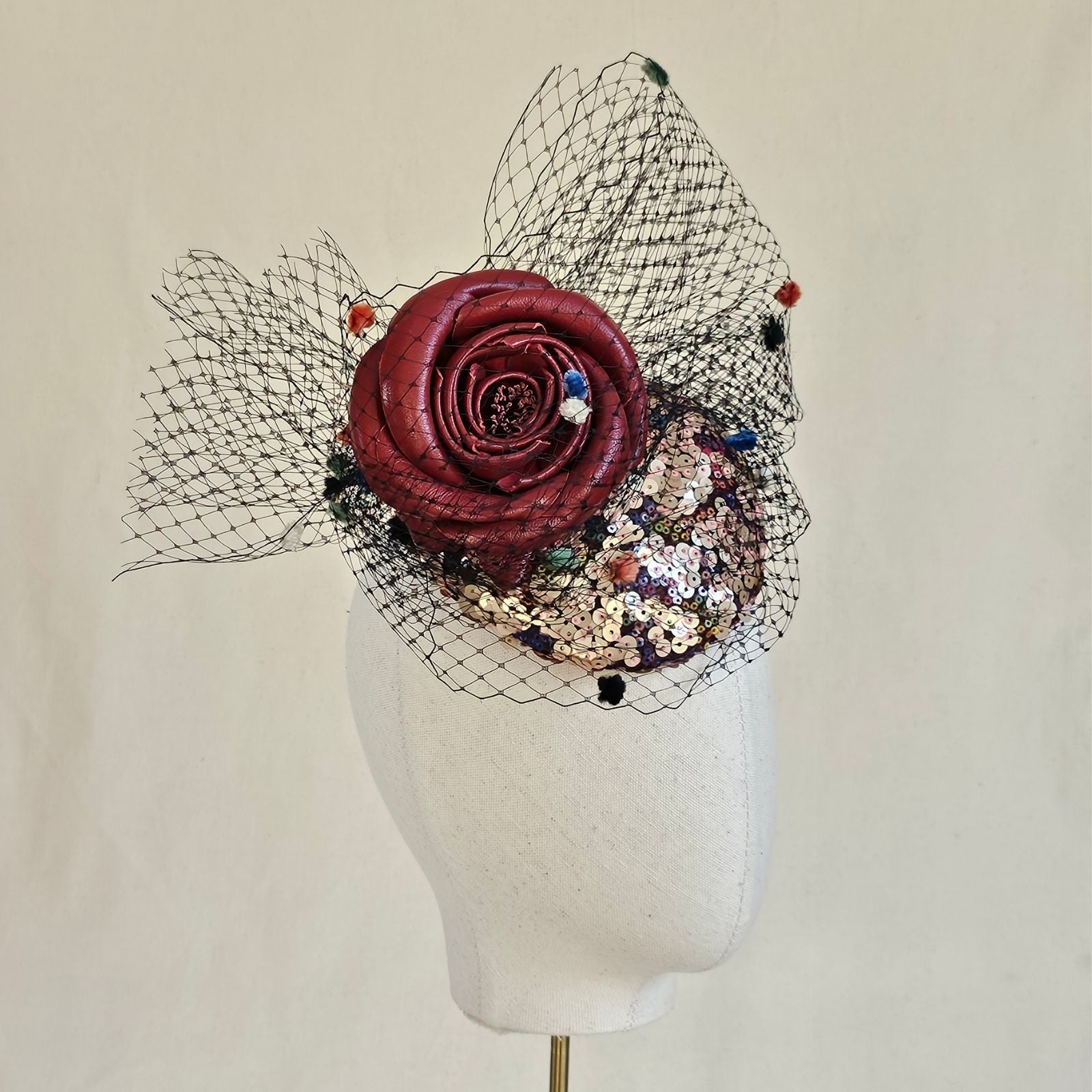 Multicolour sequin mini beret with red rose embellishment and spot veiling, side view.