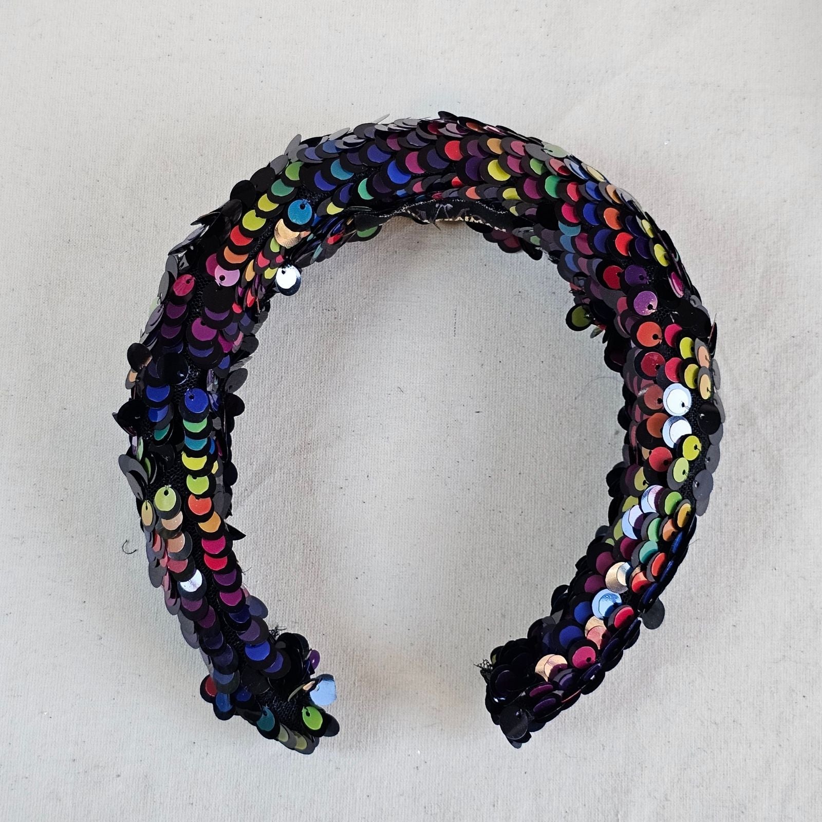 Multicoloured sequin headband, top view.