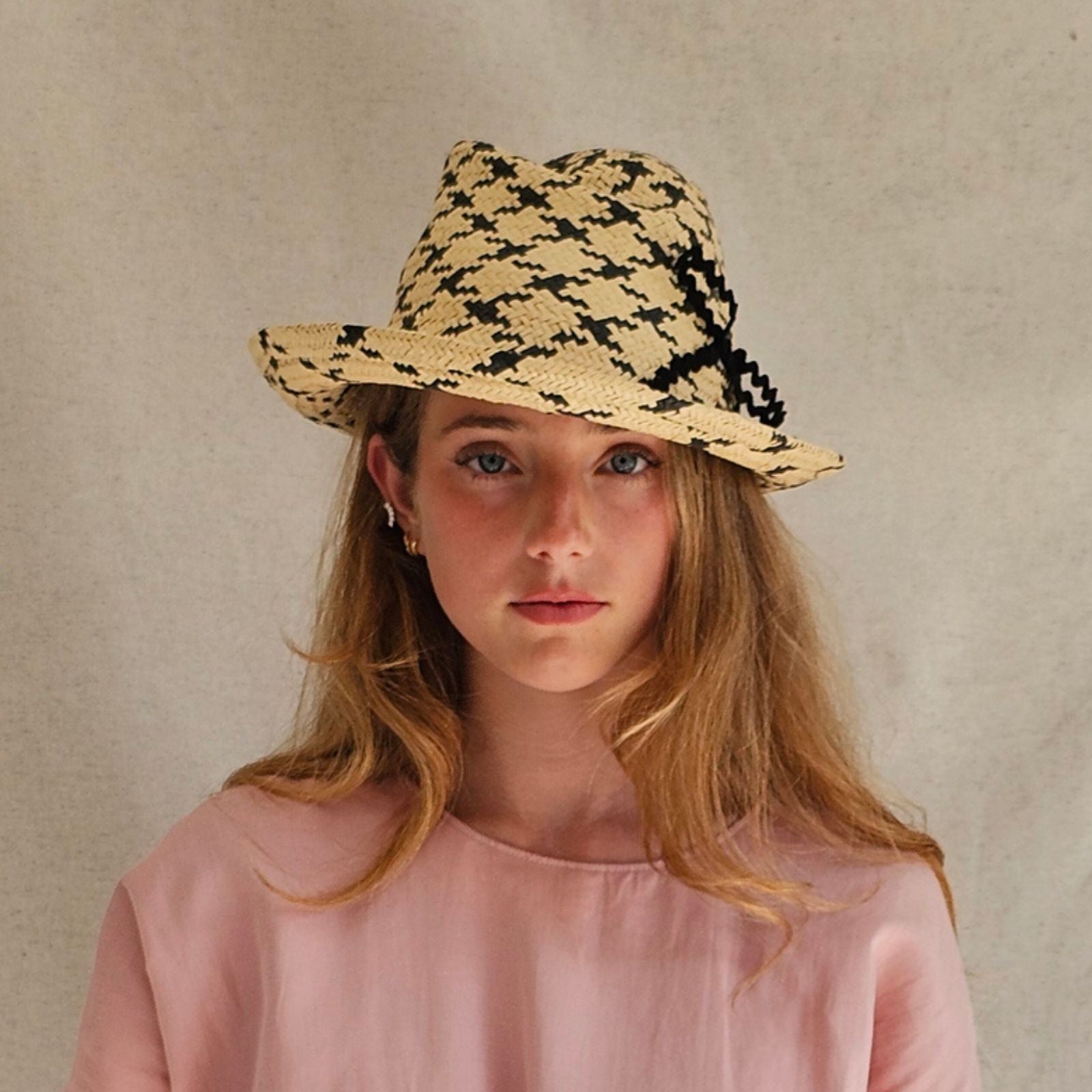 Natural and black check straw trilby with beautiful bow embellishment, front view.