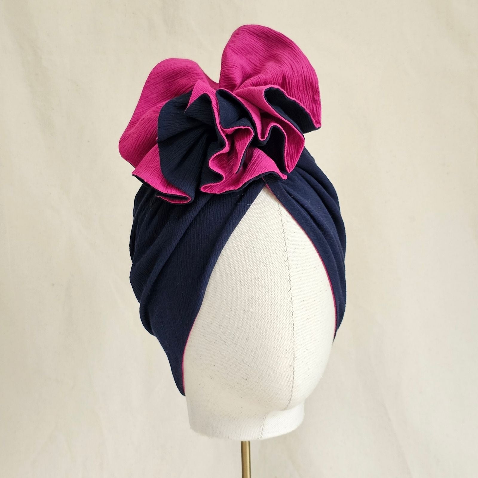 Navy and fuchsia cotton turban with intricate ruffle, angle view.