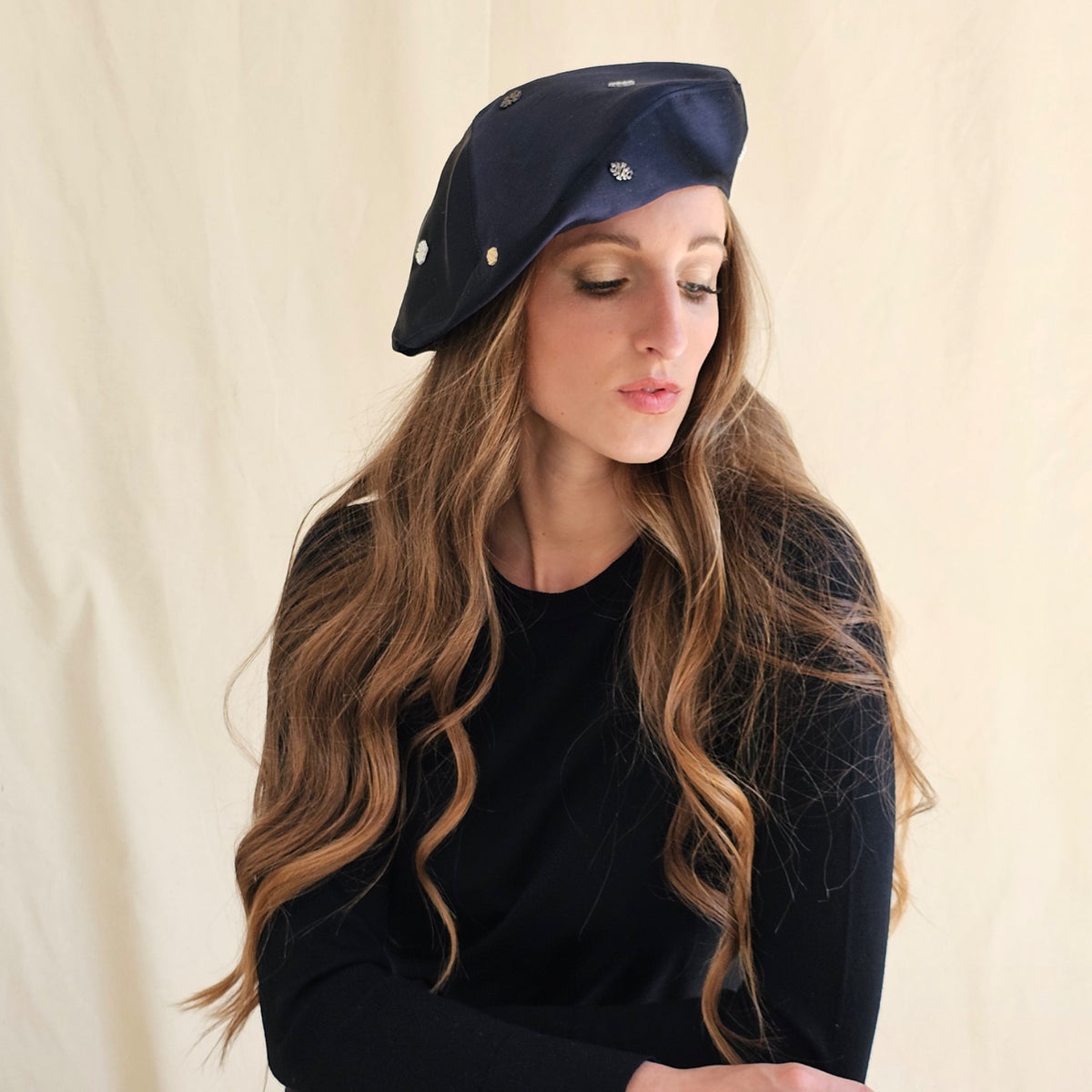 Angled view of navy silk duchesse satin tam o'shanter showing
stitched monograms.