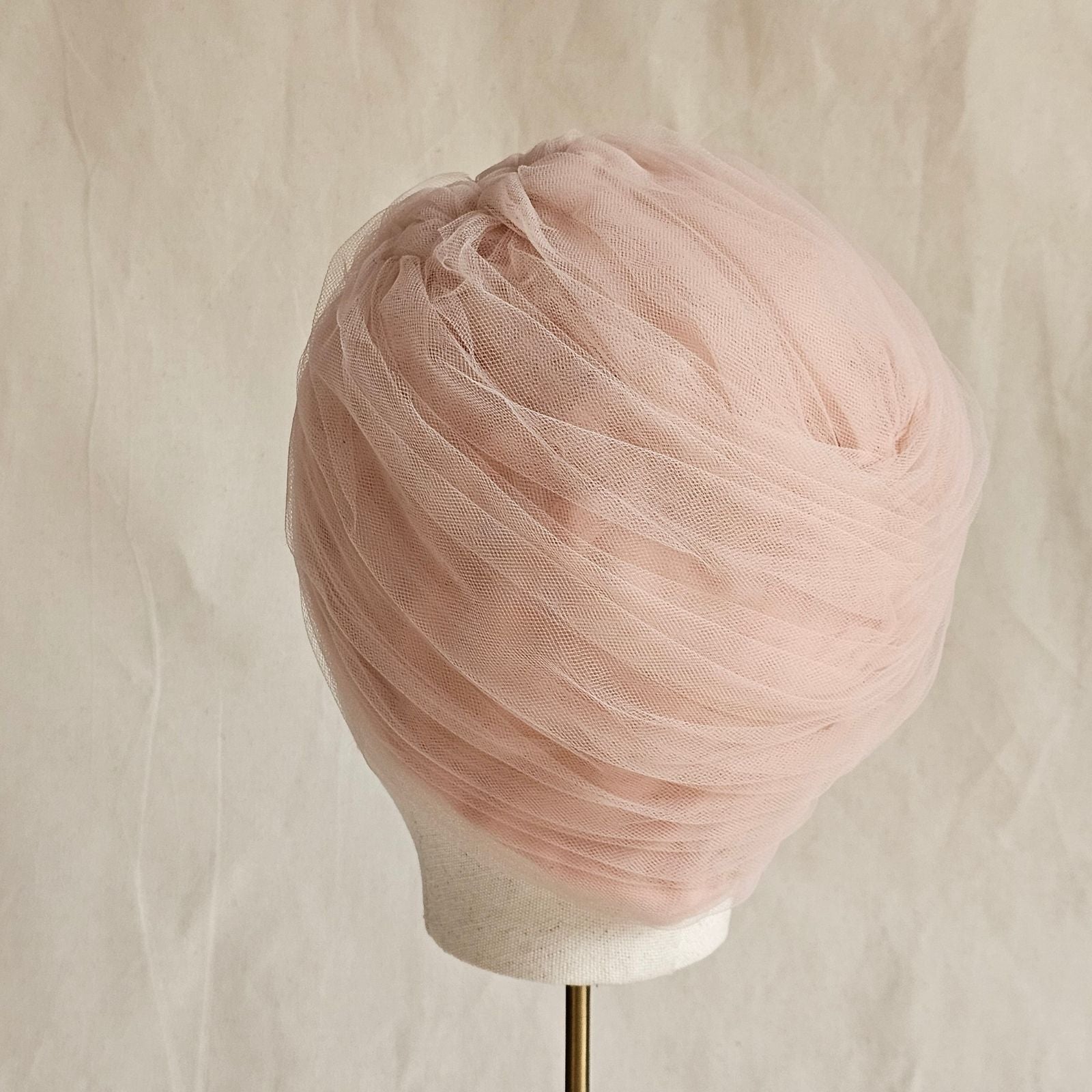 Nude tulle turban braided intricately, back view.