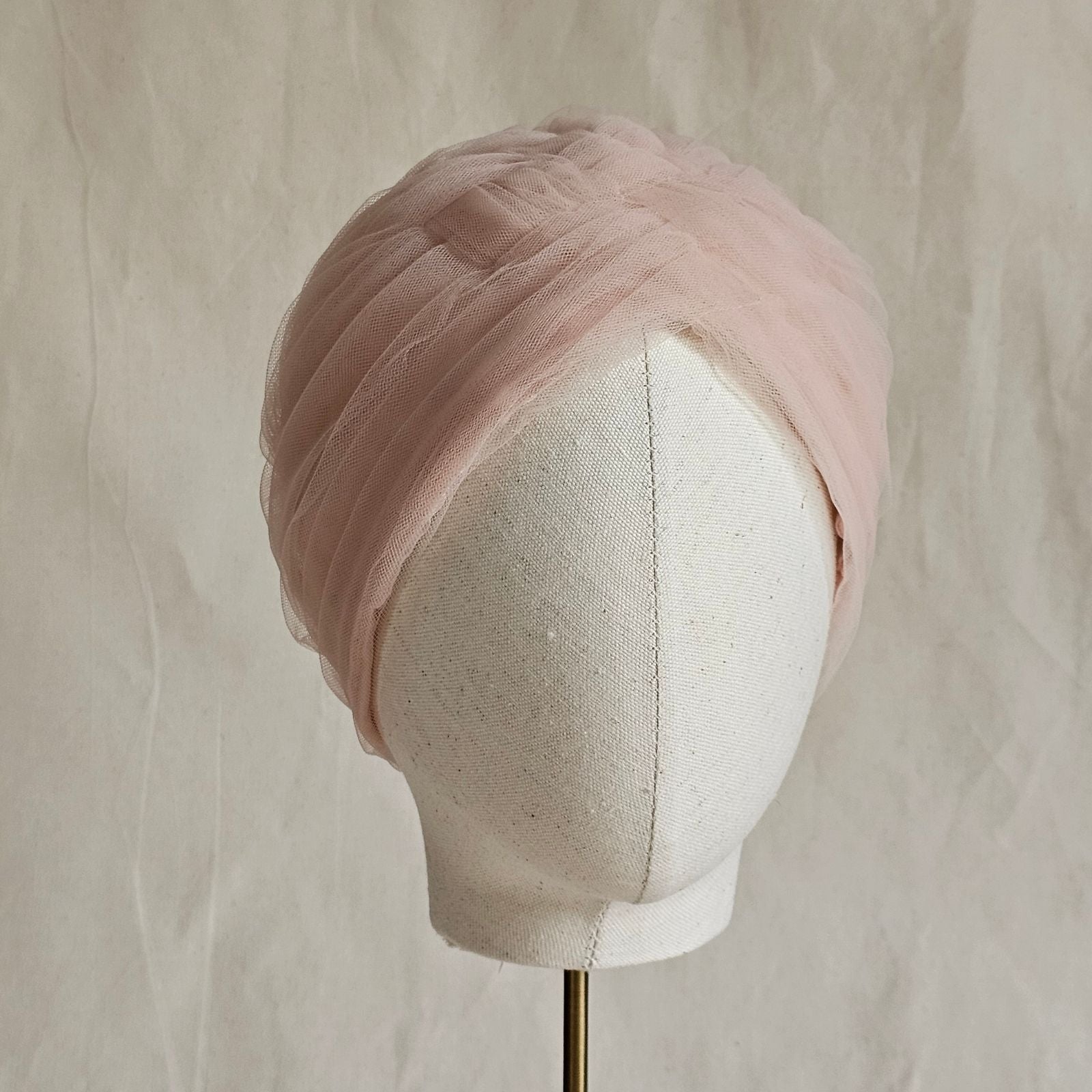 Nude tulle turban braided intricately, front view.
