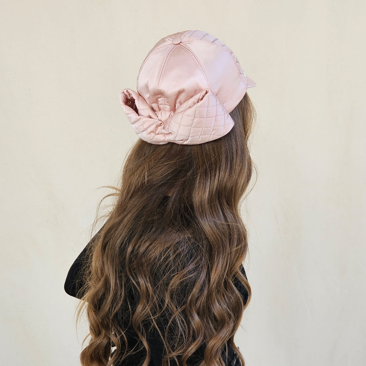 Back view of blush pink silk satin baseball cap showing oversized
quilted bow.