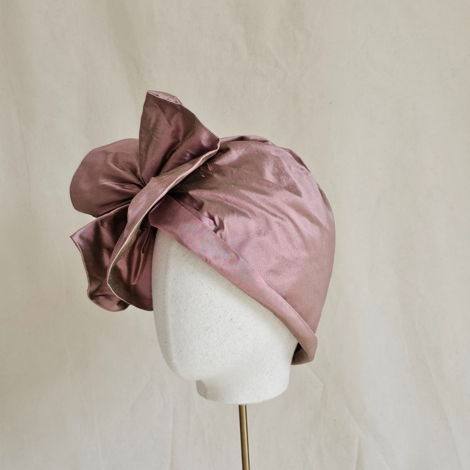 Pink silk turban with beautiful flower ruffle, left view.