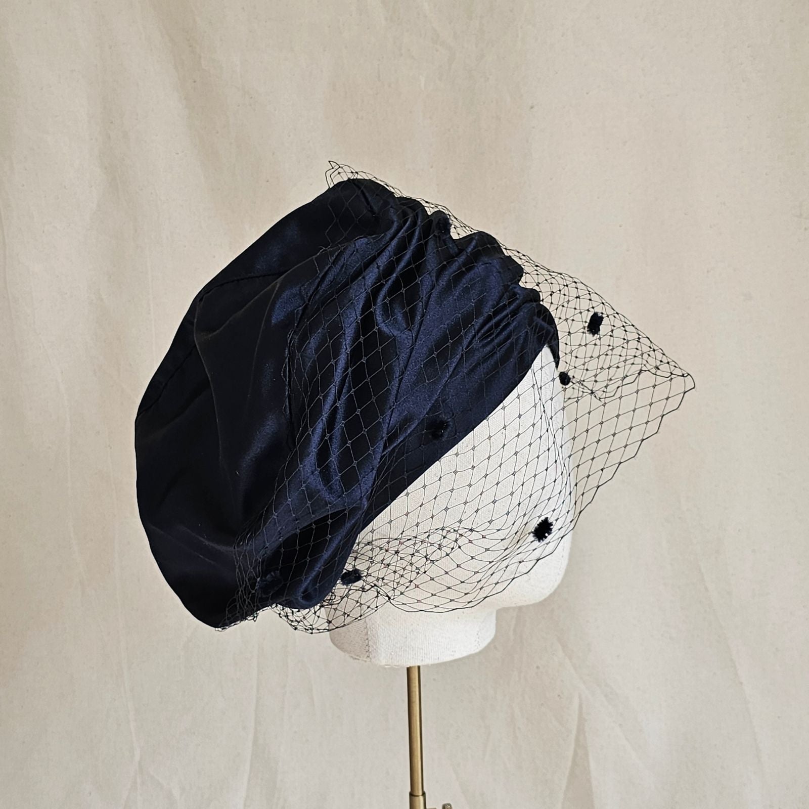 Ink silk and satin beret turban with dotted veil, side view.