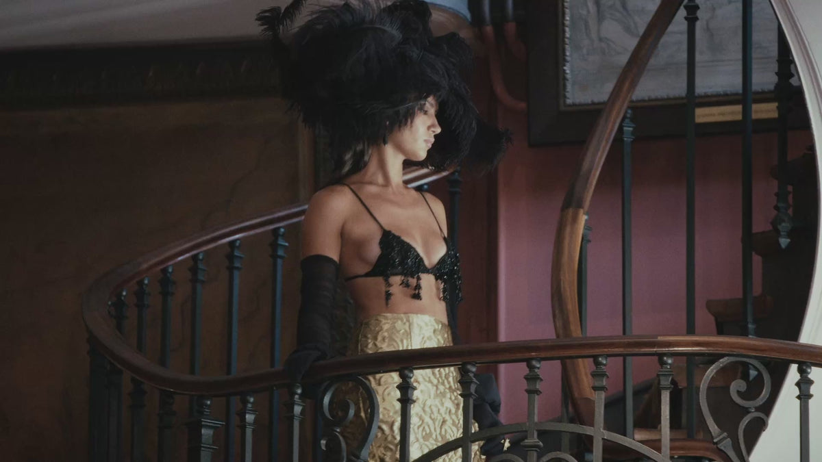 Model wearing an oversized black feather hat by Nerida Fraiman at the Azzopardi fashion show.