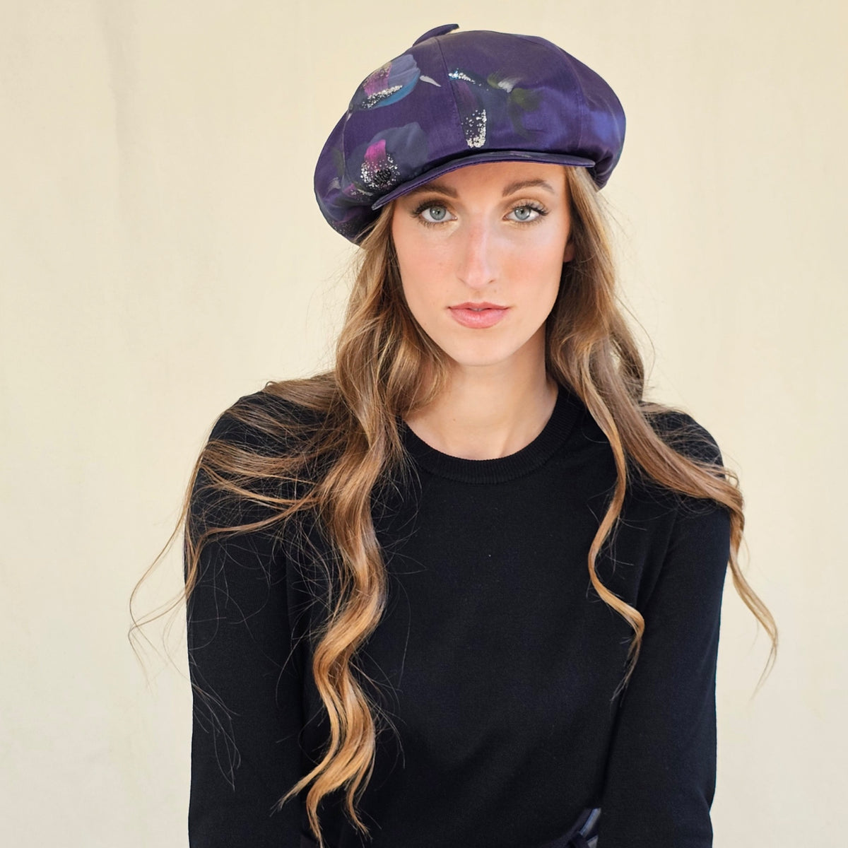 Purple hand-painted silk baker boy cap with full crown, worn on a
model.