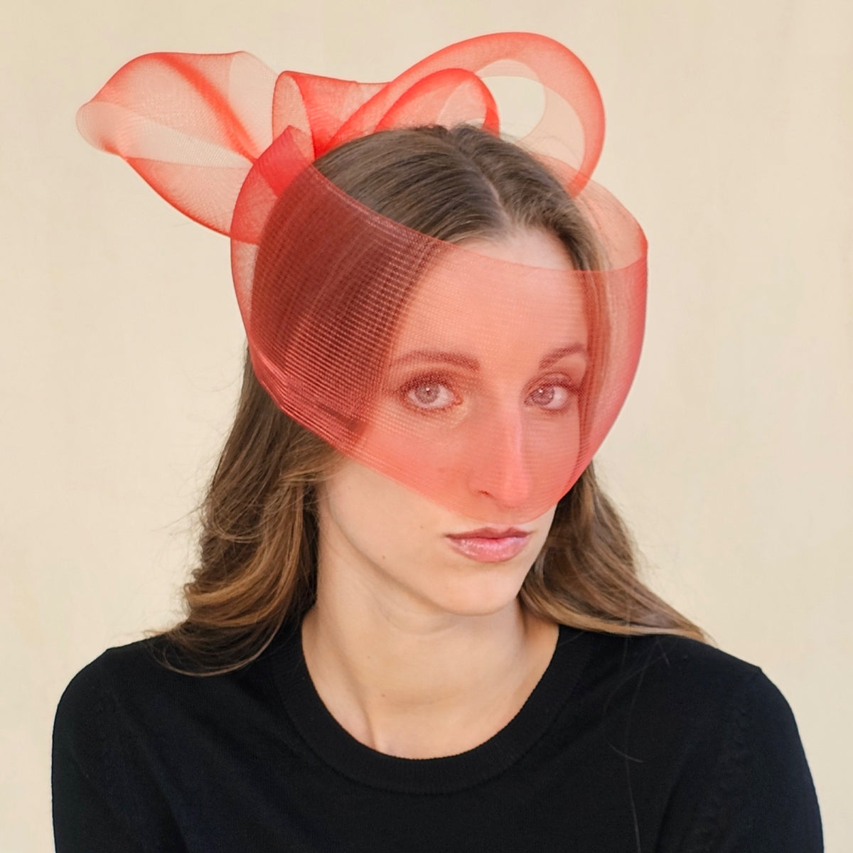 Red crin bow face veil with loops rising behind the crown, worn on
a model.