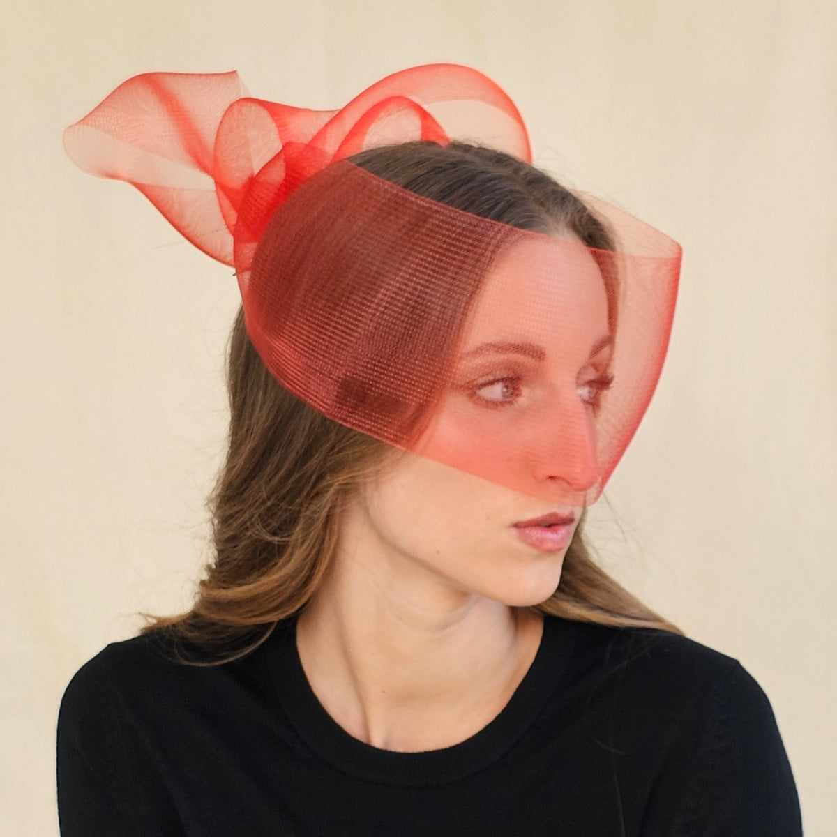 Close-up of red crin bow face veil showing the sheer curved front.