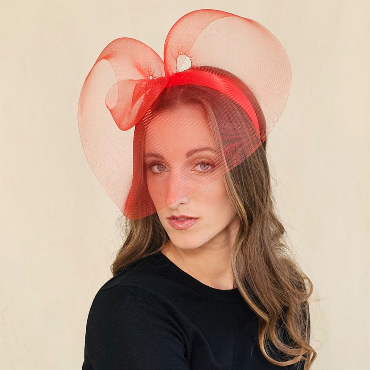 Red sculptural crin loop headpiece on headband with sheer curves framing the
face.