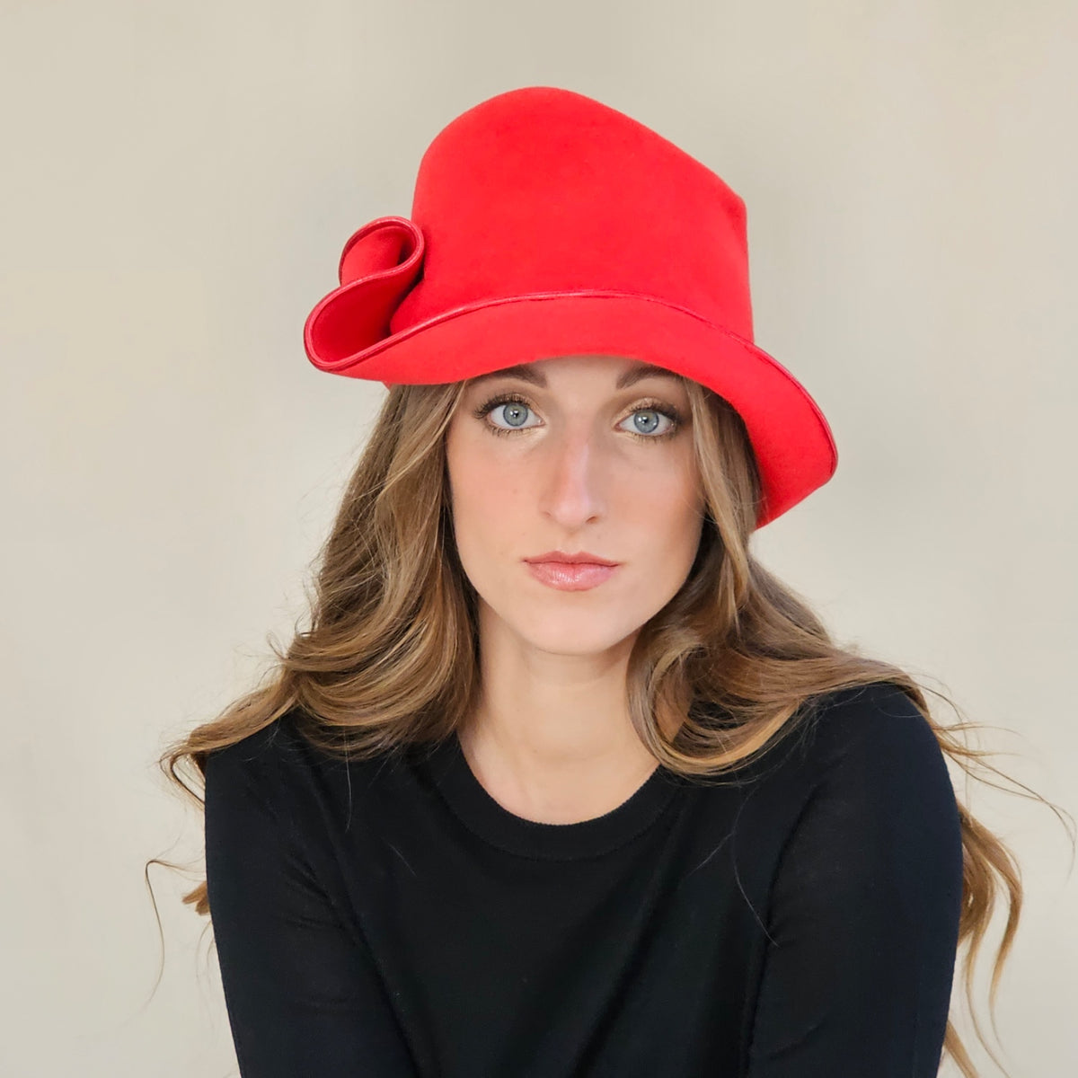 Front close-up of red felt cloche showing asymmetric brim.