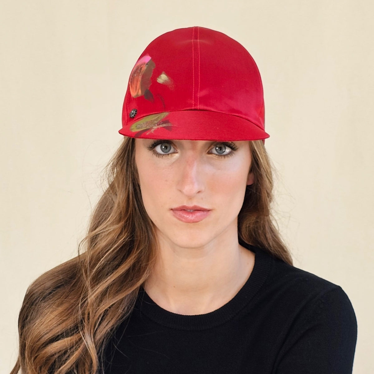 Front close-up of red hand-painted silk baseball cap showing
painted crown and peak.