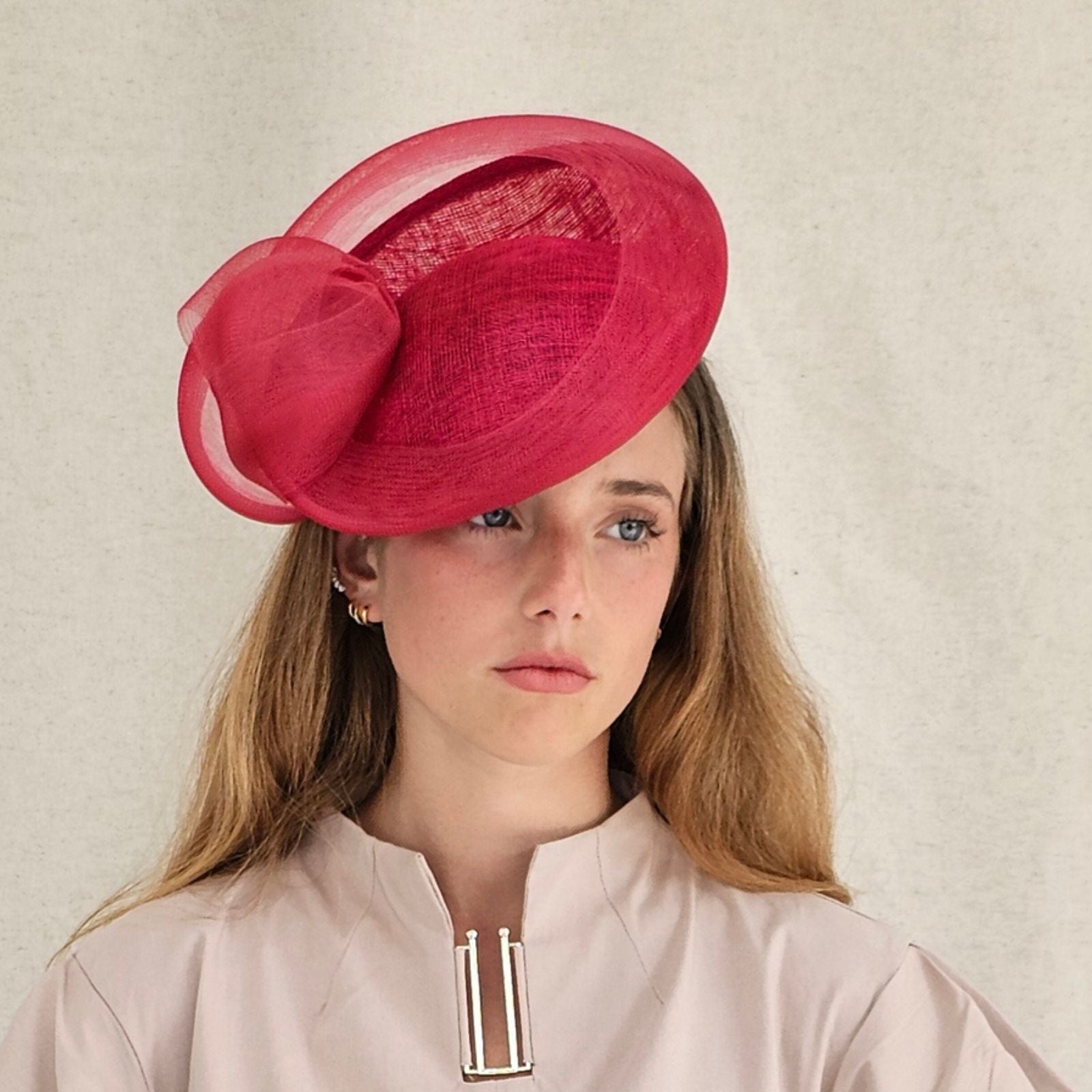 Red straw disc hat with beautiful crin knotted swirl, front view.