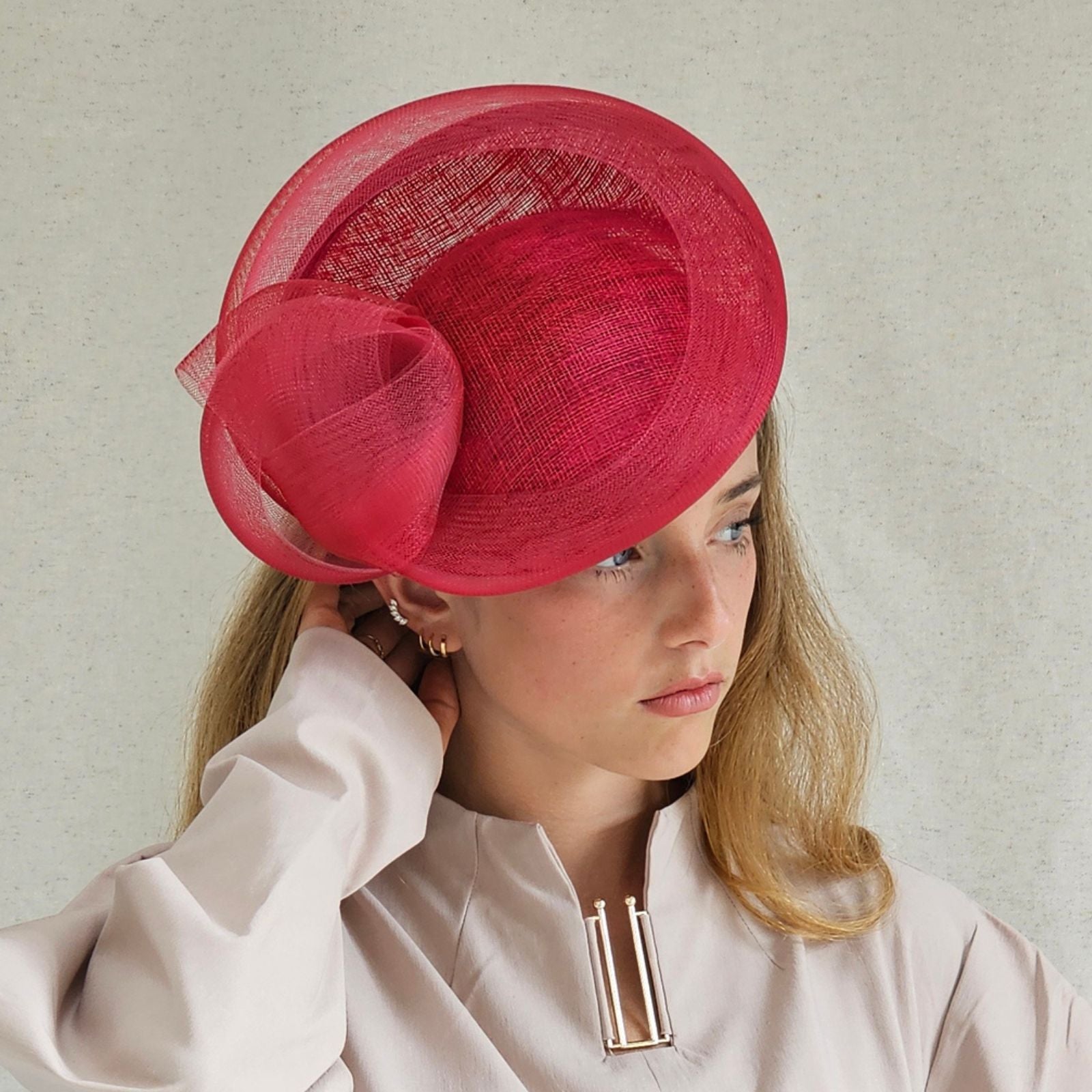 Red straw disc hat with beautiful crin knotted swirl, side view.