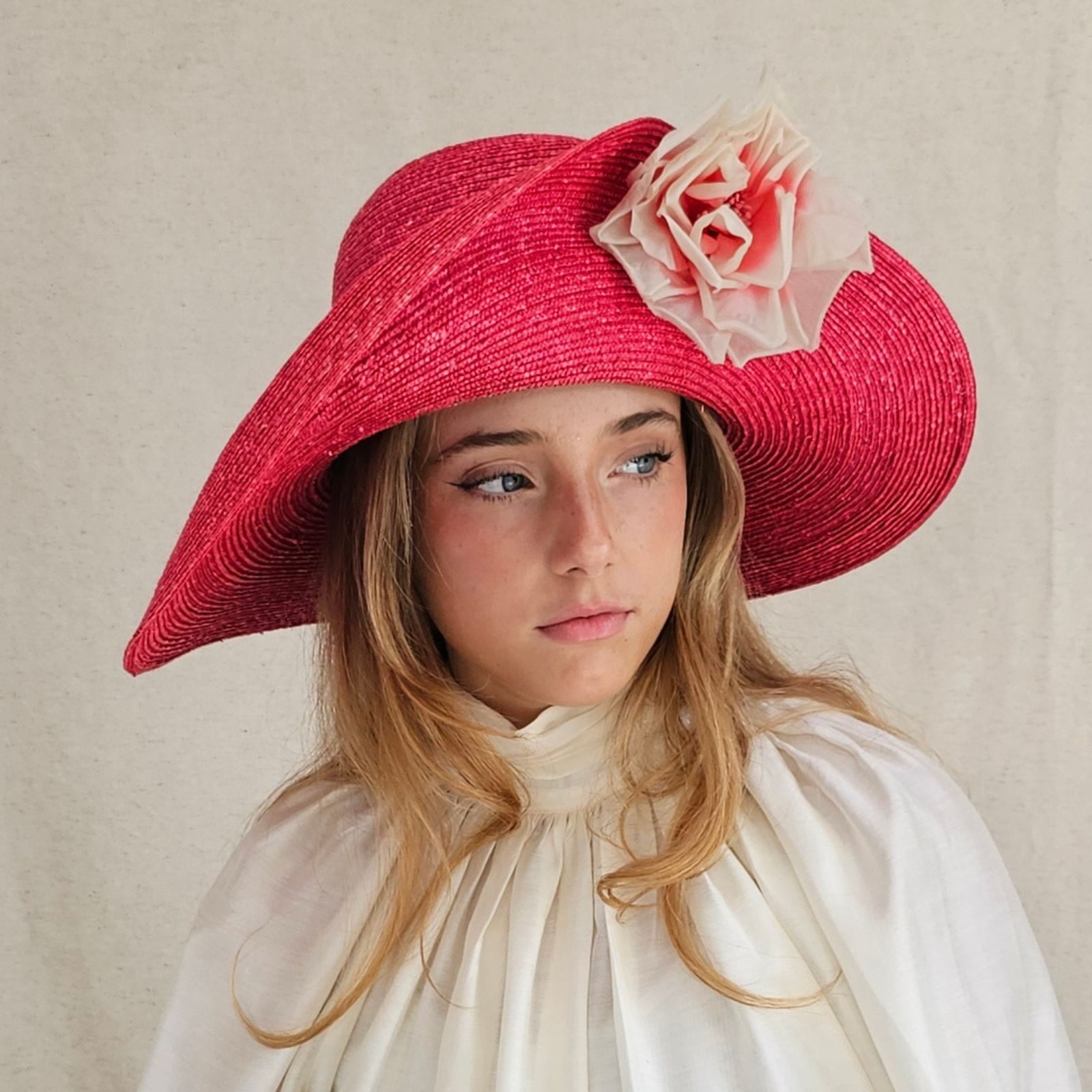 Red straw sunhat with beautiful flower embellishment, frontside view.