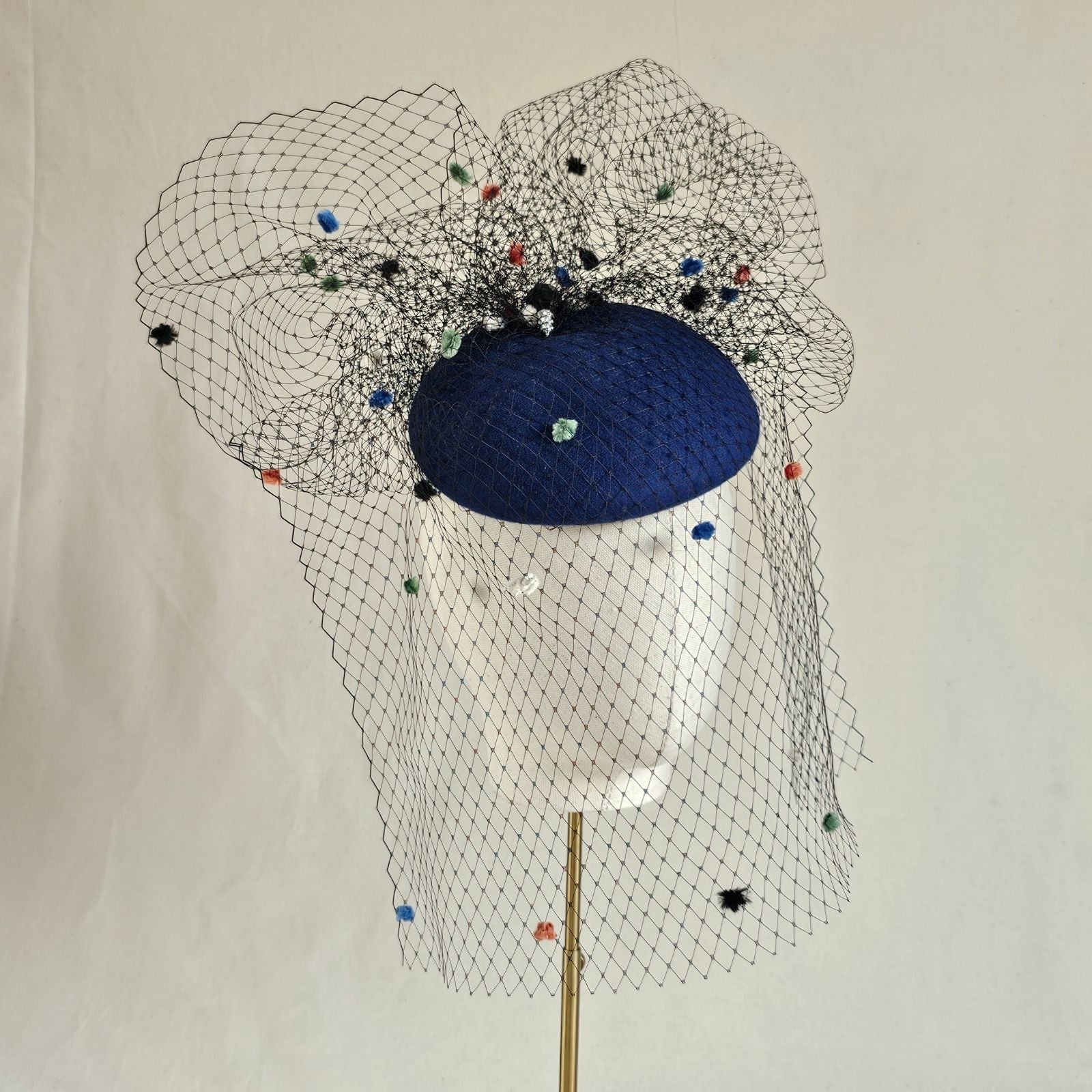 Royal blue felt beret with multicolour dot veiling, front view.
