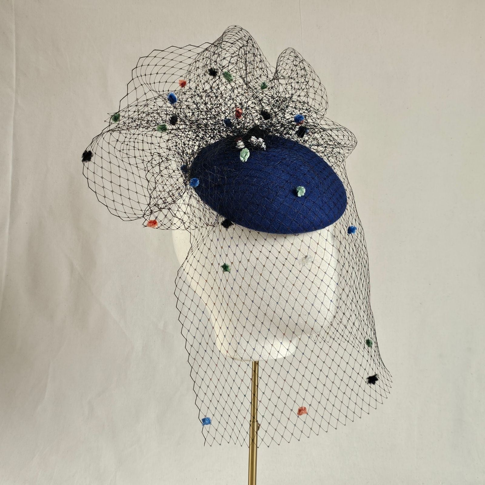Royal blue felt beret with multicolour dot veiling, side view.