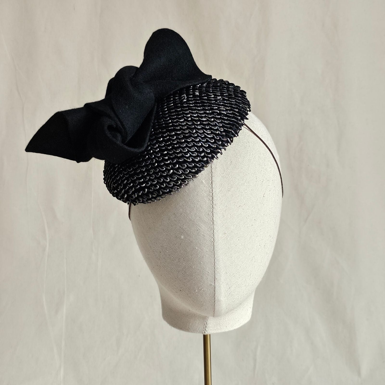Silver black mini beret with black bow embellishment, front view.