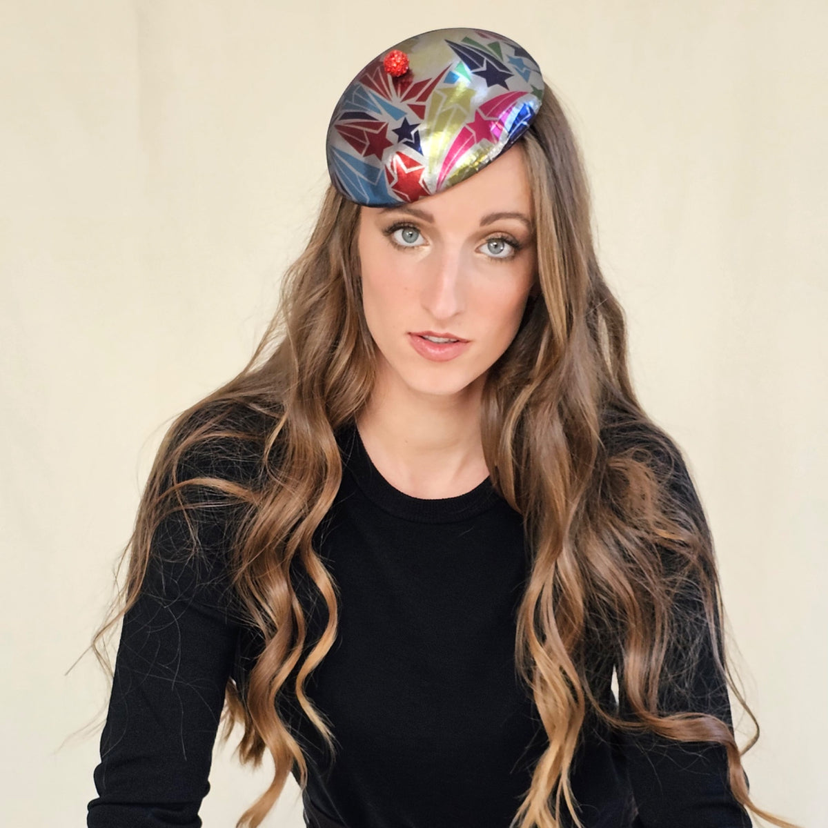Silver star-patterned beret with a red globe, worn tilted on a model.