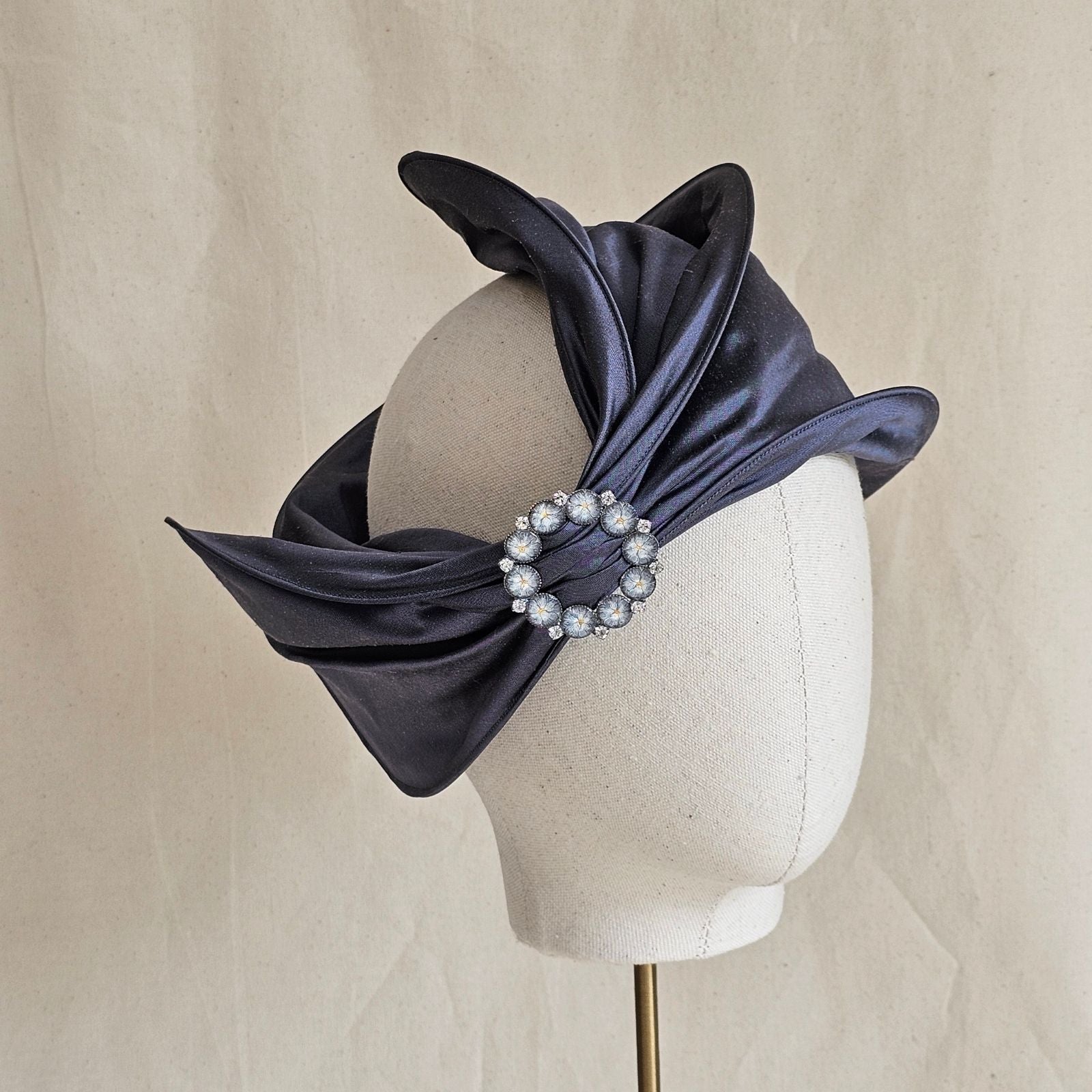 Slate blue silk headwrap gathered into beautiful brooch, front view.