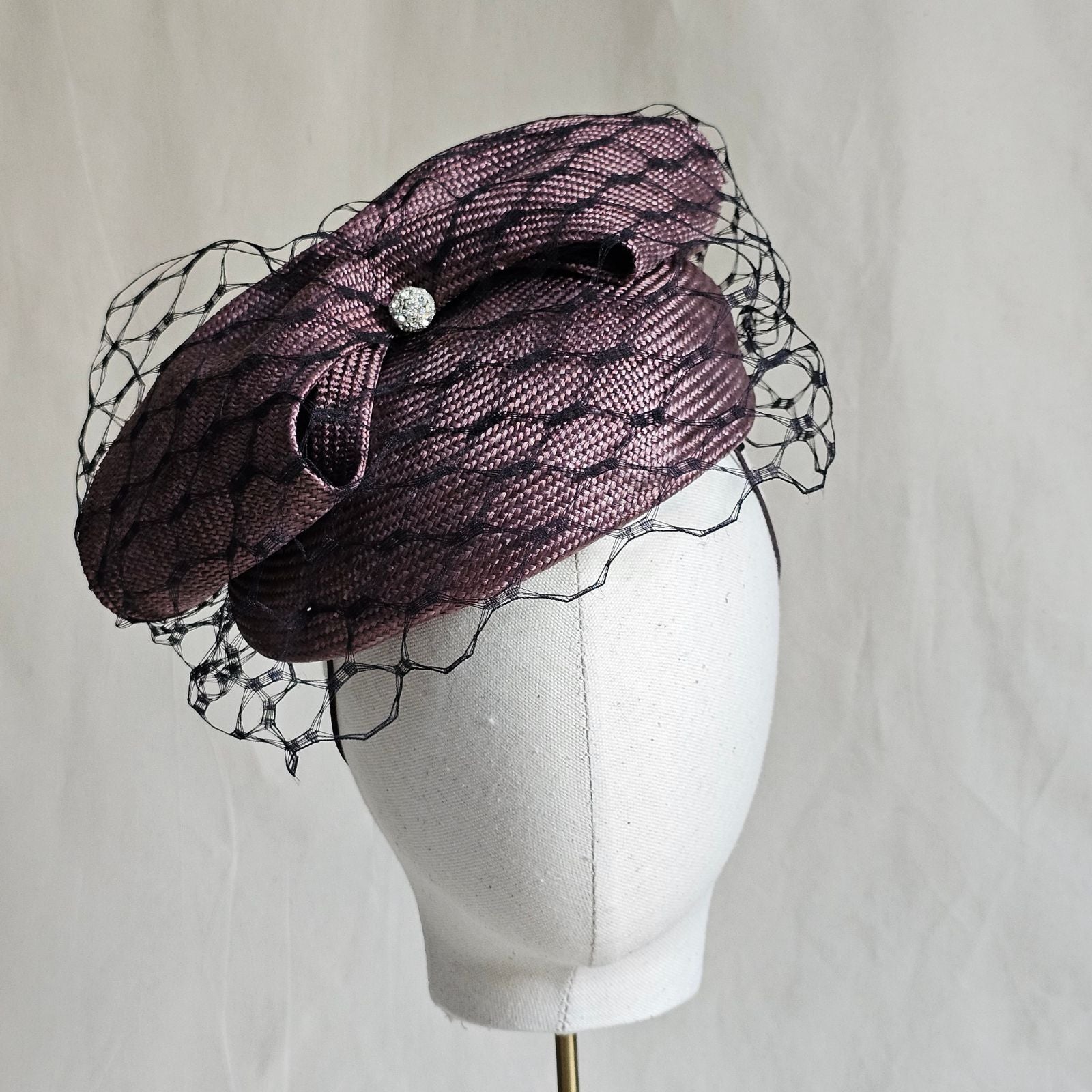 Taupe straw beret with beautiful bow and black veiling, front view.