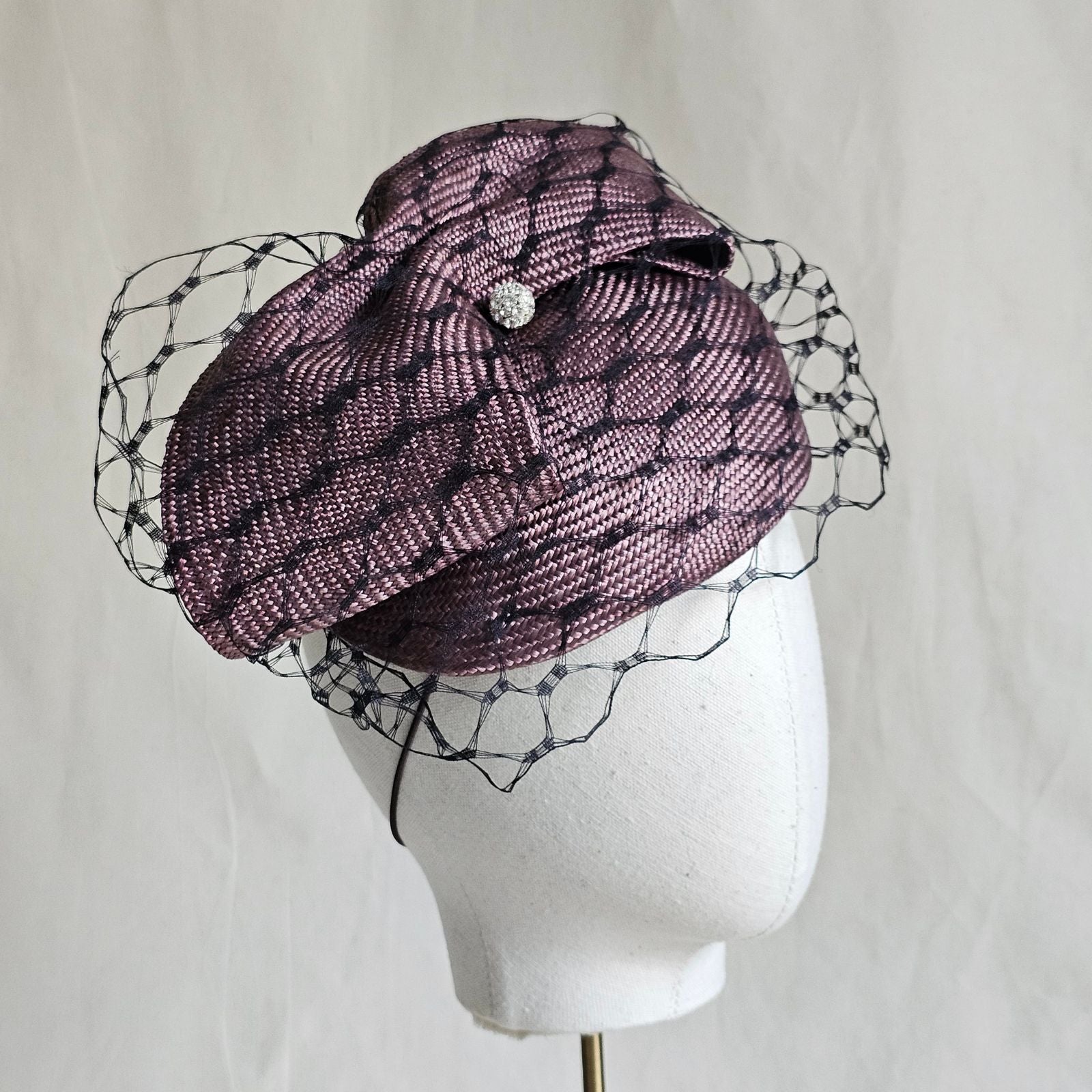 Taupe straw beret with beautiful bow and black veiling, side view.