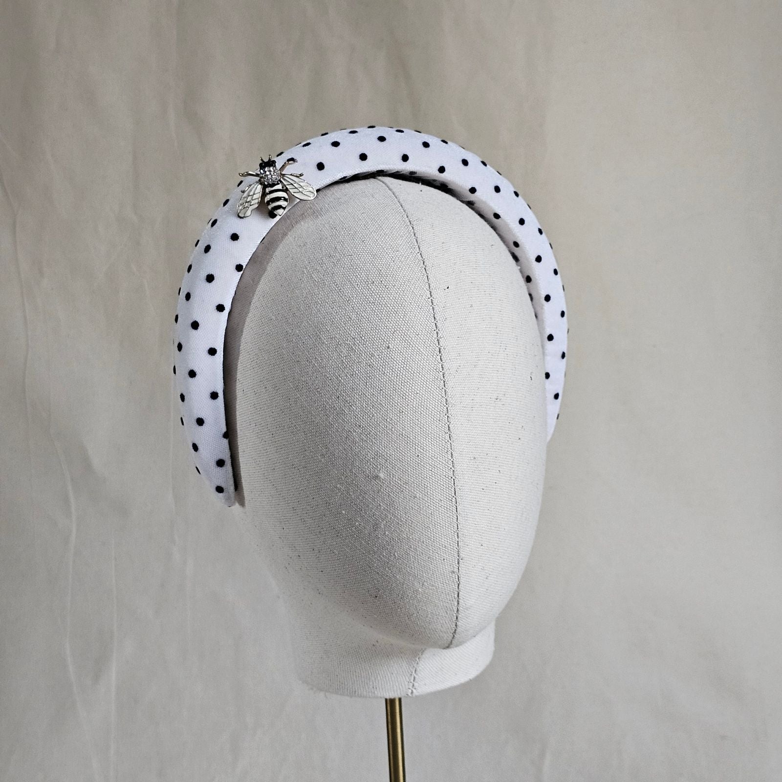 White headband with black dots and beautiful bee embellishment, right view.