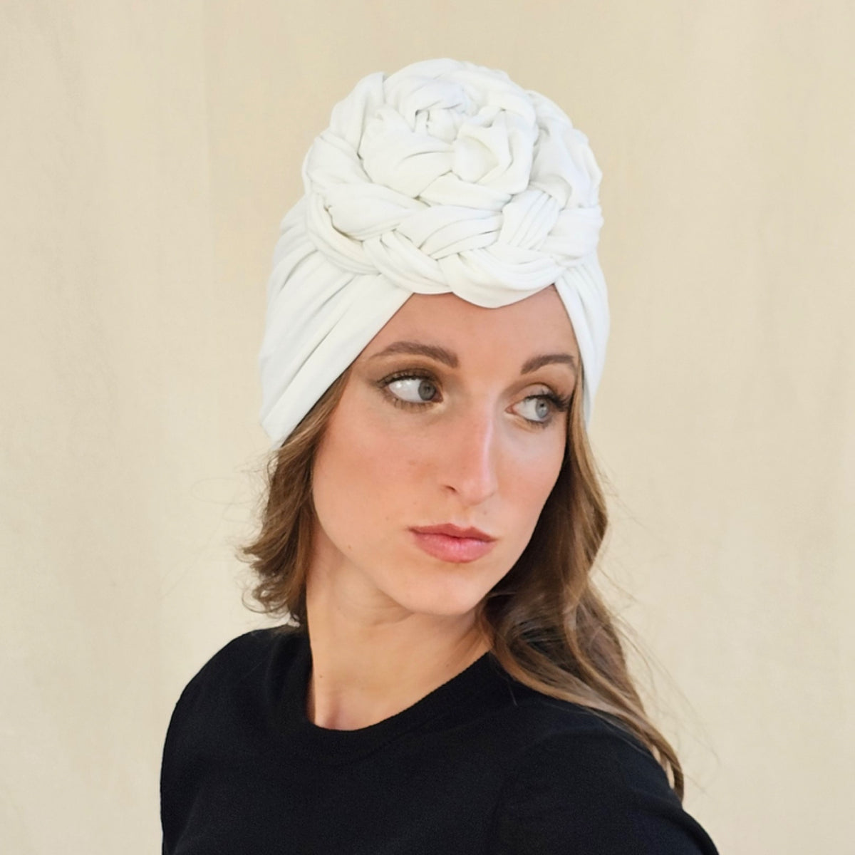 White jersey turban showing the sculptural braid rose above the
forehead.